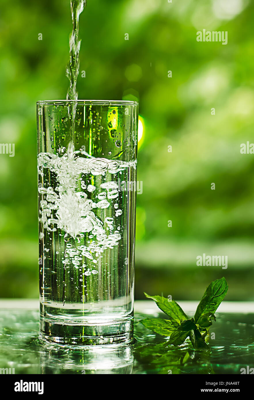 Cool fresh water with ice and mint. Splash in glass. Healthy life concept Stock Photo
