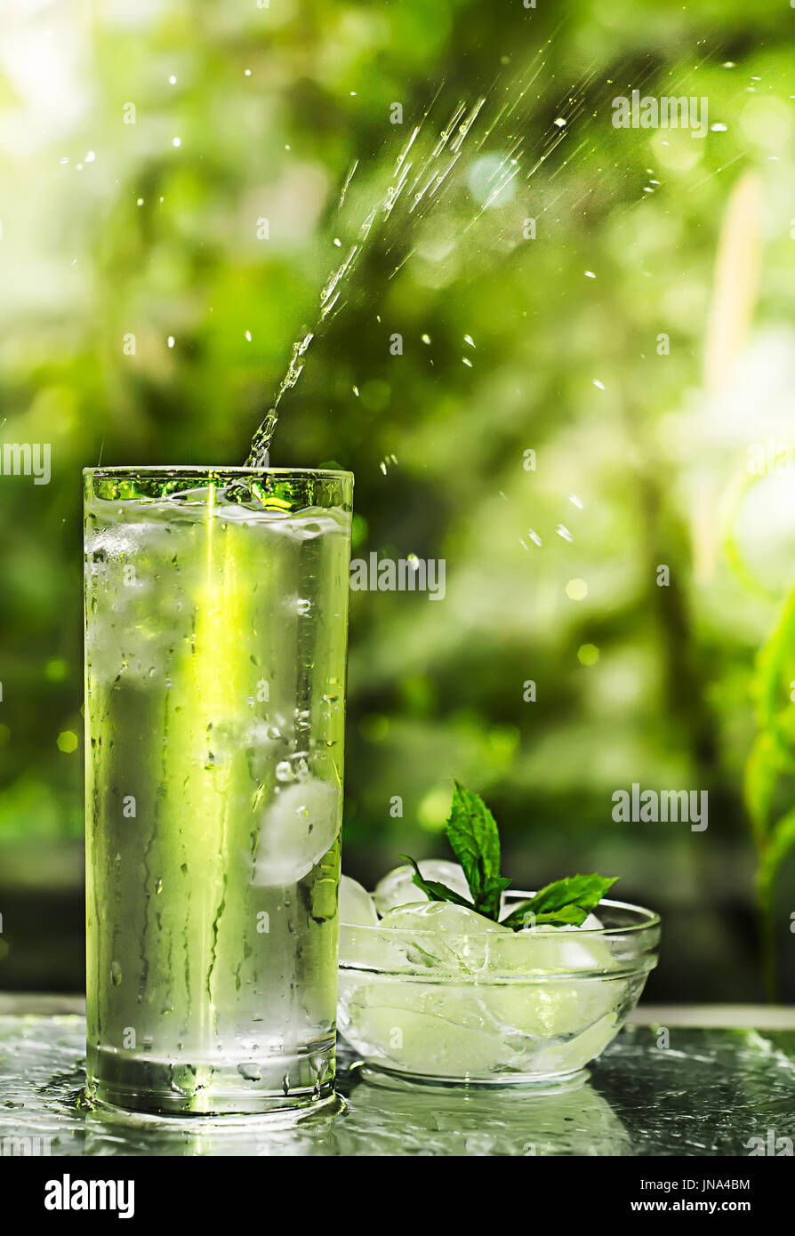 Cool fresh water with ice and mint. Splash in glass. Healthy life concept Stock Photo