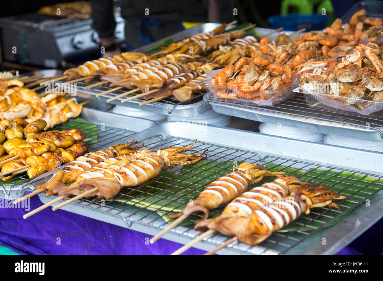 Octopus and chicken skewers at a street food stall in Chatuchak Market, Bangkok, Thailand Stock Photo