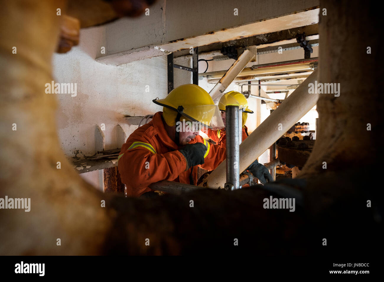 A member of the fire team on a north sea oil and as rig, using his radio, as part a emergency response exercise. credit: LEE RAMSDEN / ALAMY Stock Photo