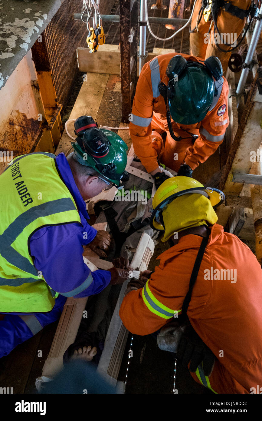 A first aider in blue coveralls / overalls, fireman and medic on an emergency response exercise. credit: LEE RAMSDEN / ALAMY Stock Photo