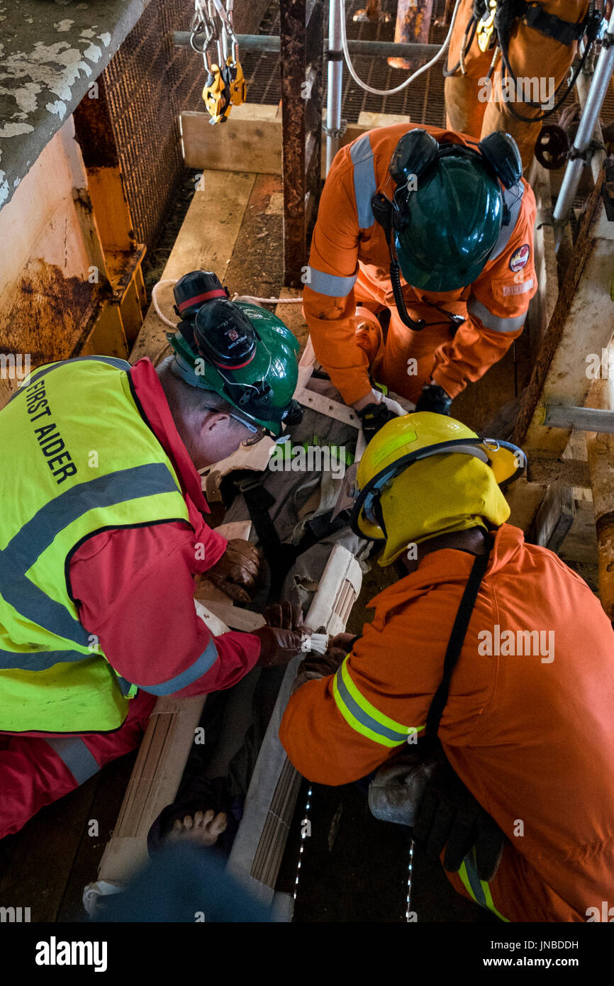 A first aider in red coveralls / overalls, fireman and medic on an emergency response exercise. credit: LEE RAMSDEN / ALAMY Stock Photo