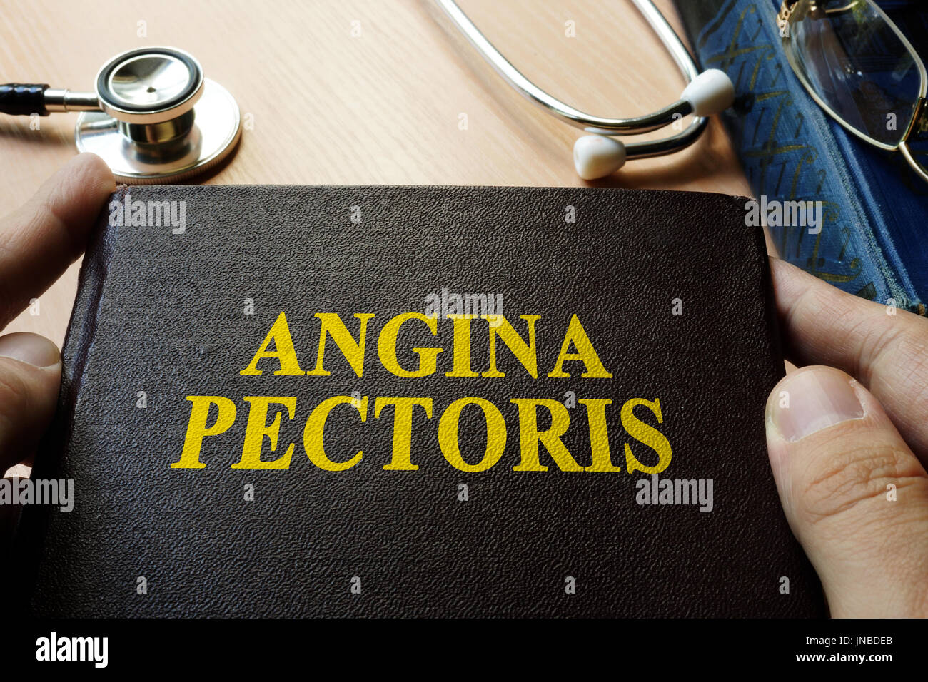 Title Angina pectoris on a book which holding doctor. Stock Photo