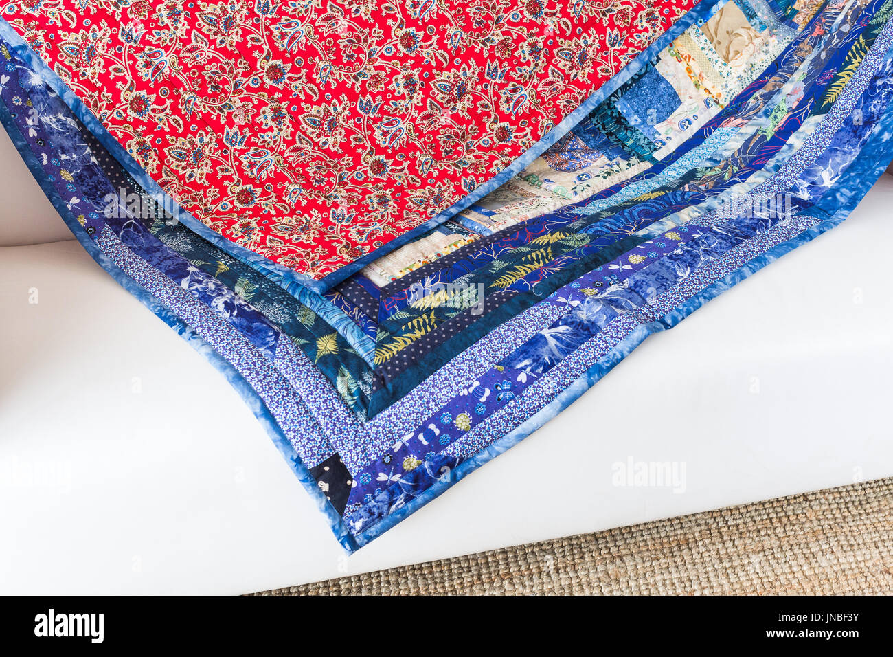 quilting, interior, culture, hobby, passion, handcraft concept - bright multicolored blanket is decorated with various flowers, leaves, dragonflies an Stock Photo
