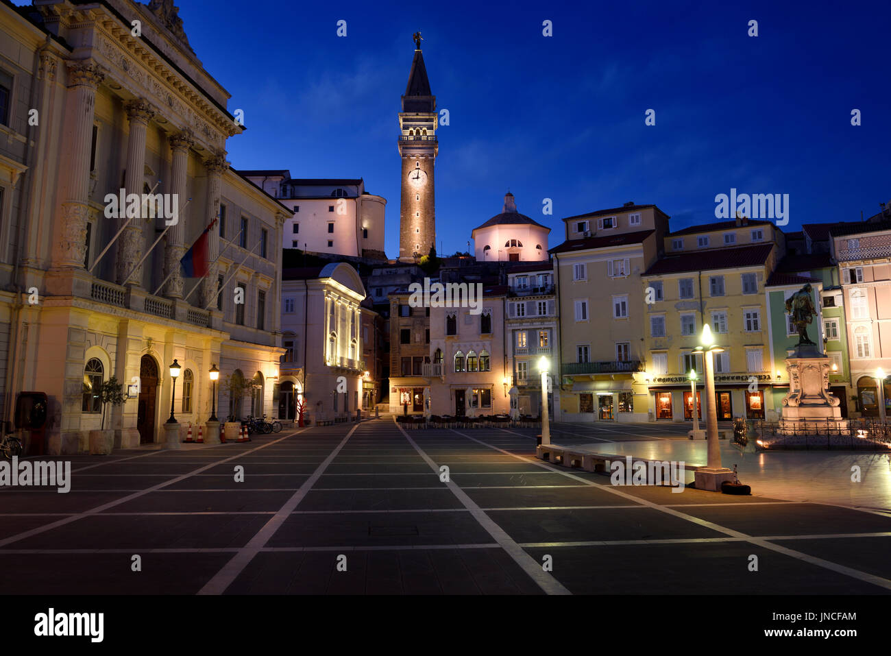 Tartini Square in Piran Slovenia with City Hall, Venetian House, Tartini statue, and St. George's Parish Church with baptistry at dusk twilight Stock Photo