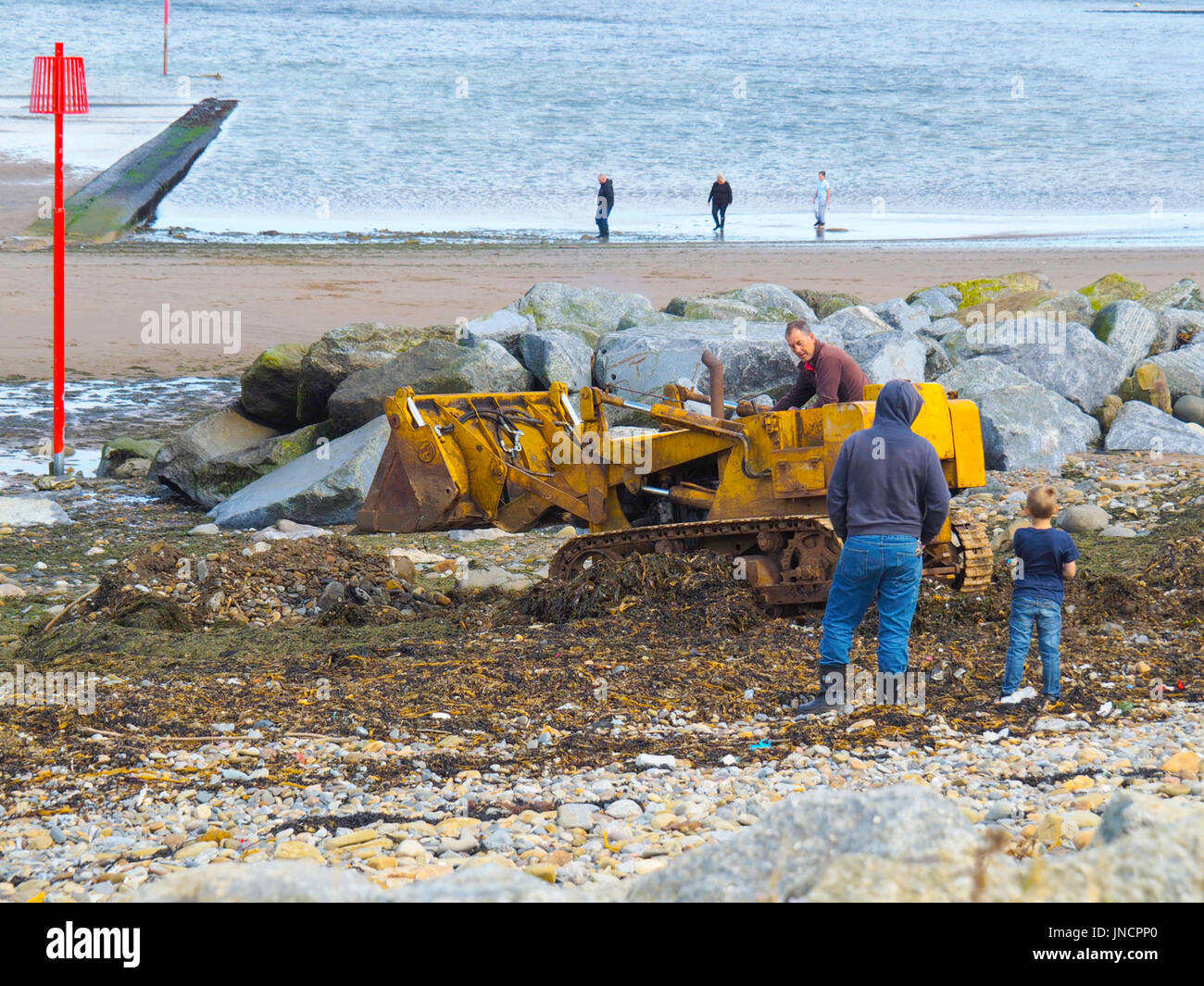 A local man using an old tracked excavator to improve access to the beach at Skinningrove North Yorkshire England Stock Photo