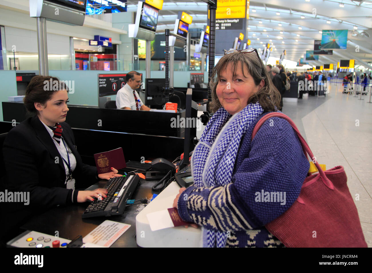 Woman Checking In At Bag Drop Desk Departure Area Terminal 5