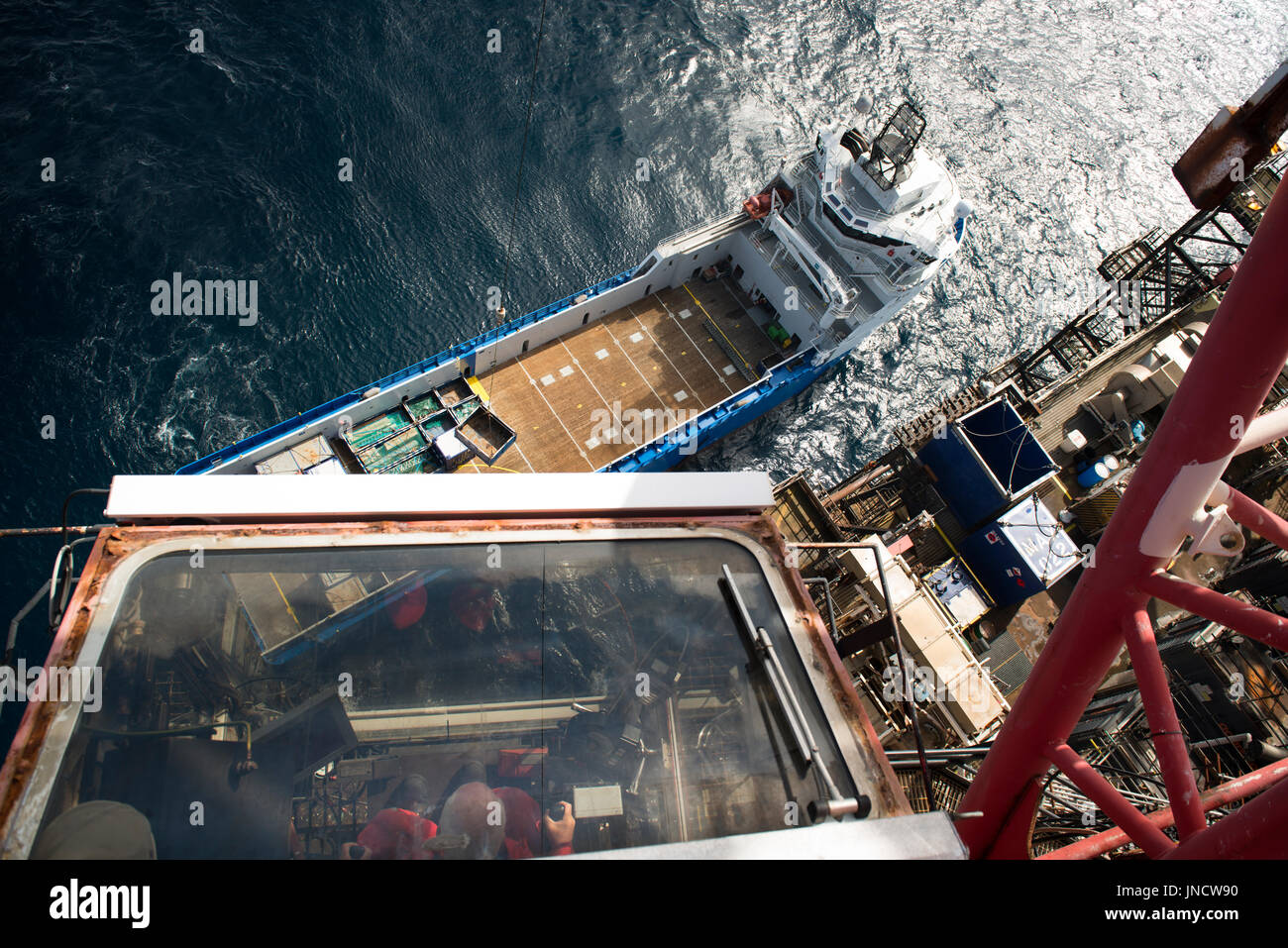 A colour image of a North sea oil and gas industry, Crane taking off supplies from the supply vessel. credit: LEE RAMSDEN / ALAMY Stock Photo