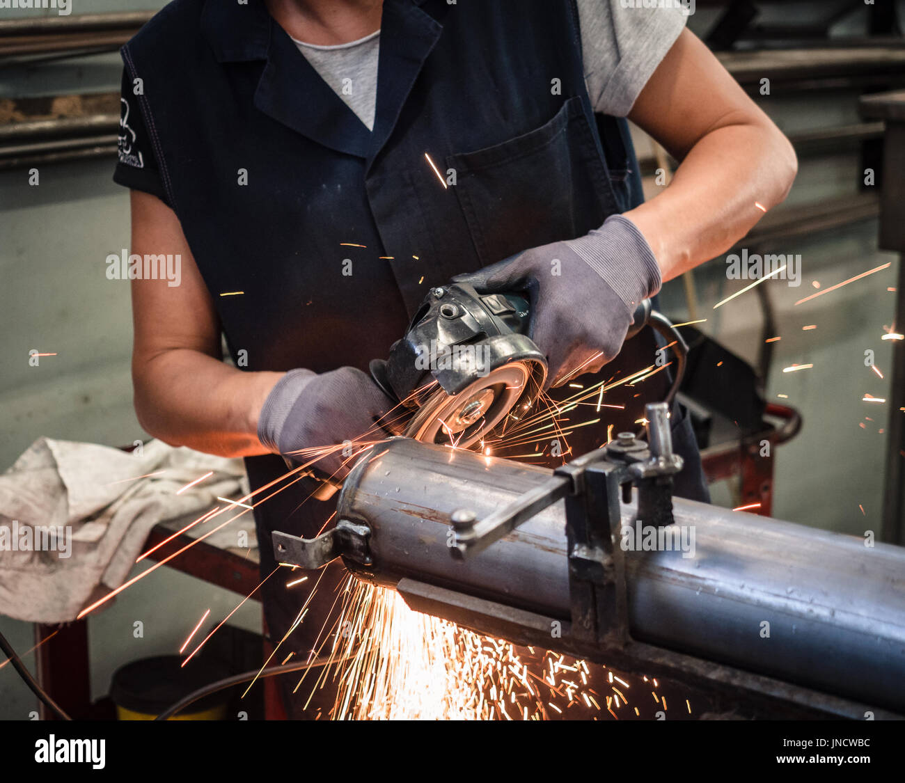 Use of angular grinder in a metalwork factory. Stock Photo