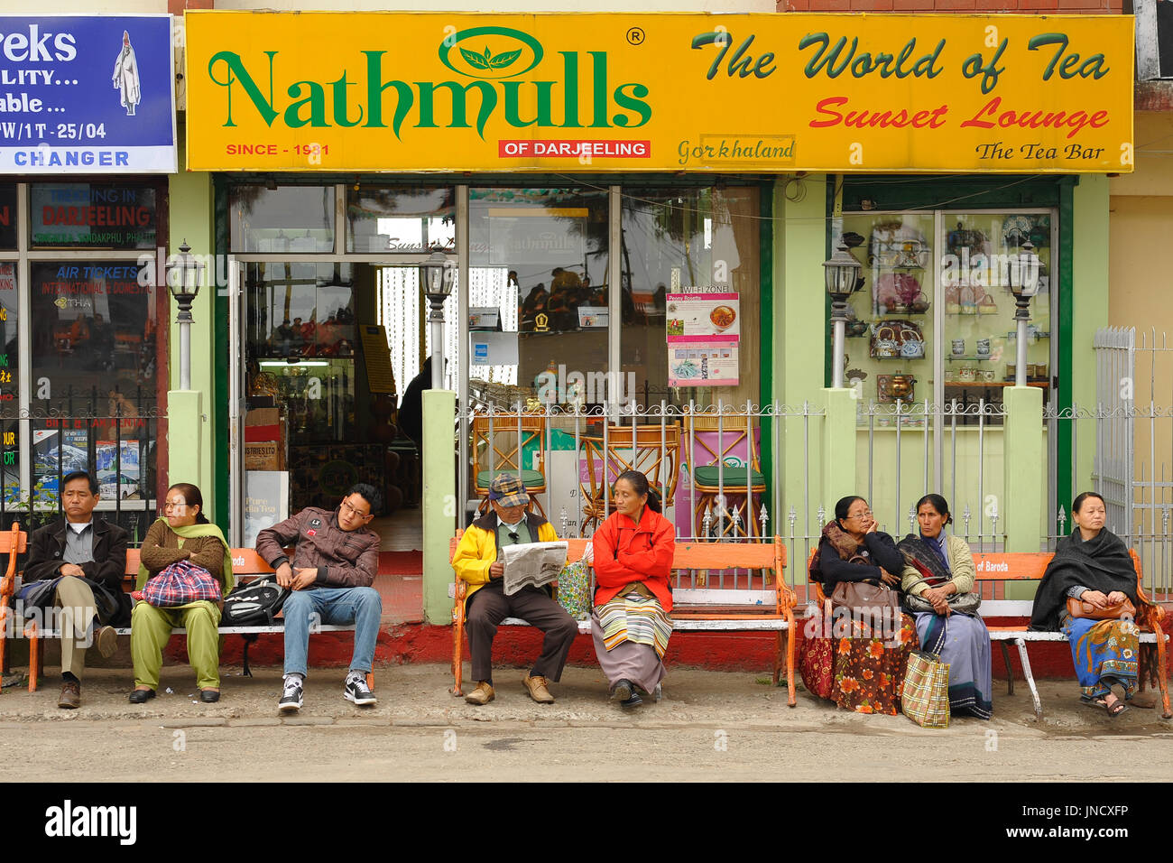 People sitting on benches outside Nathmulls Tea Bar, Darjeeling Stock Photo