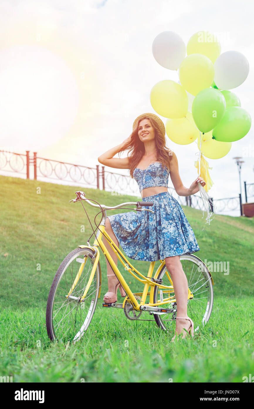 Beautiful young woman riding bicycle with hat on her head enjoying summer time Stock Photo Alamy