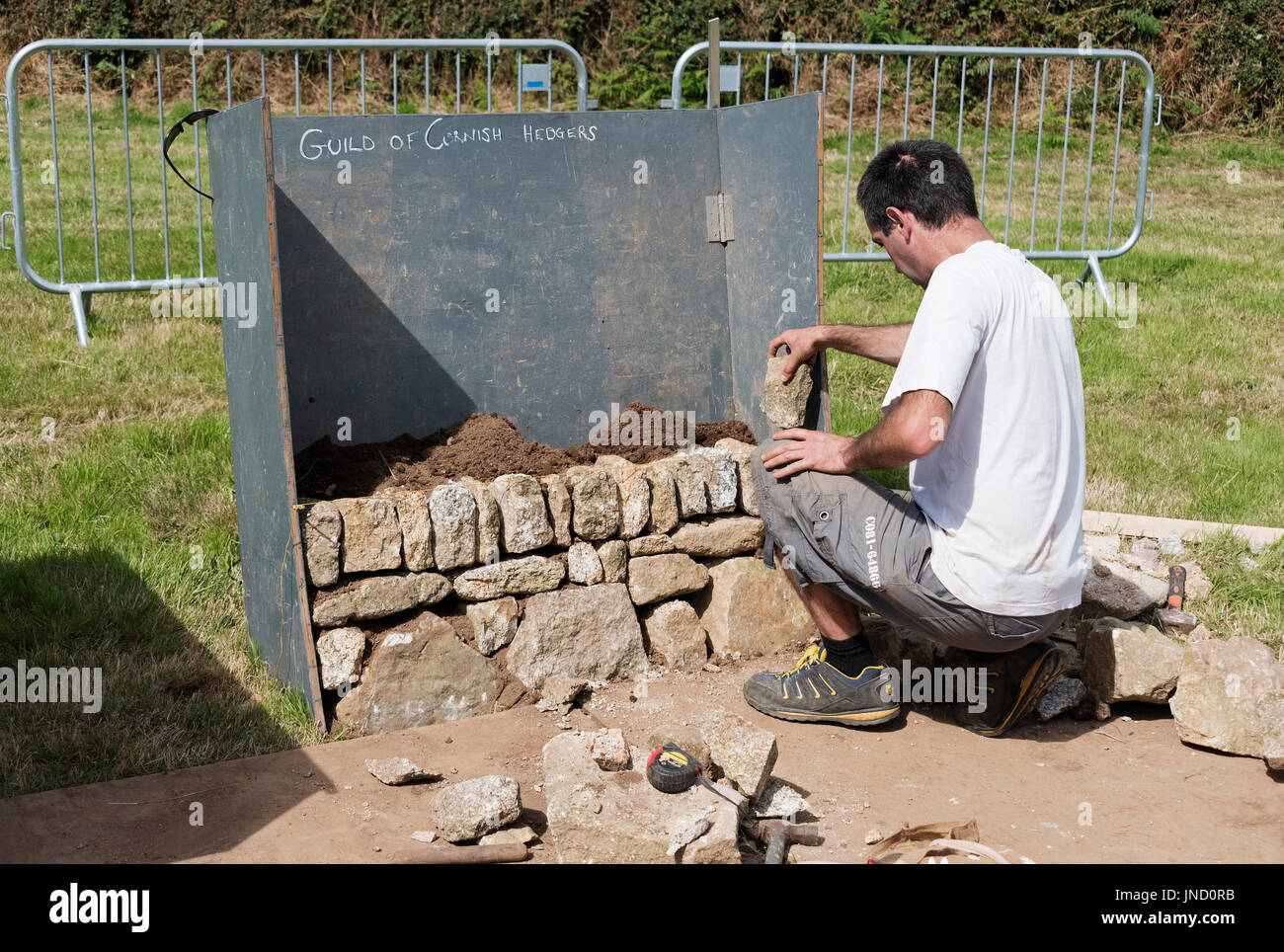 a stonemason building a traditional cornish hedge at a country show in stithians, cornwall, england, uk. Stock Photo