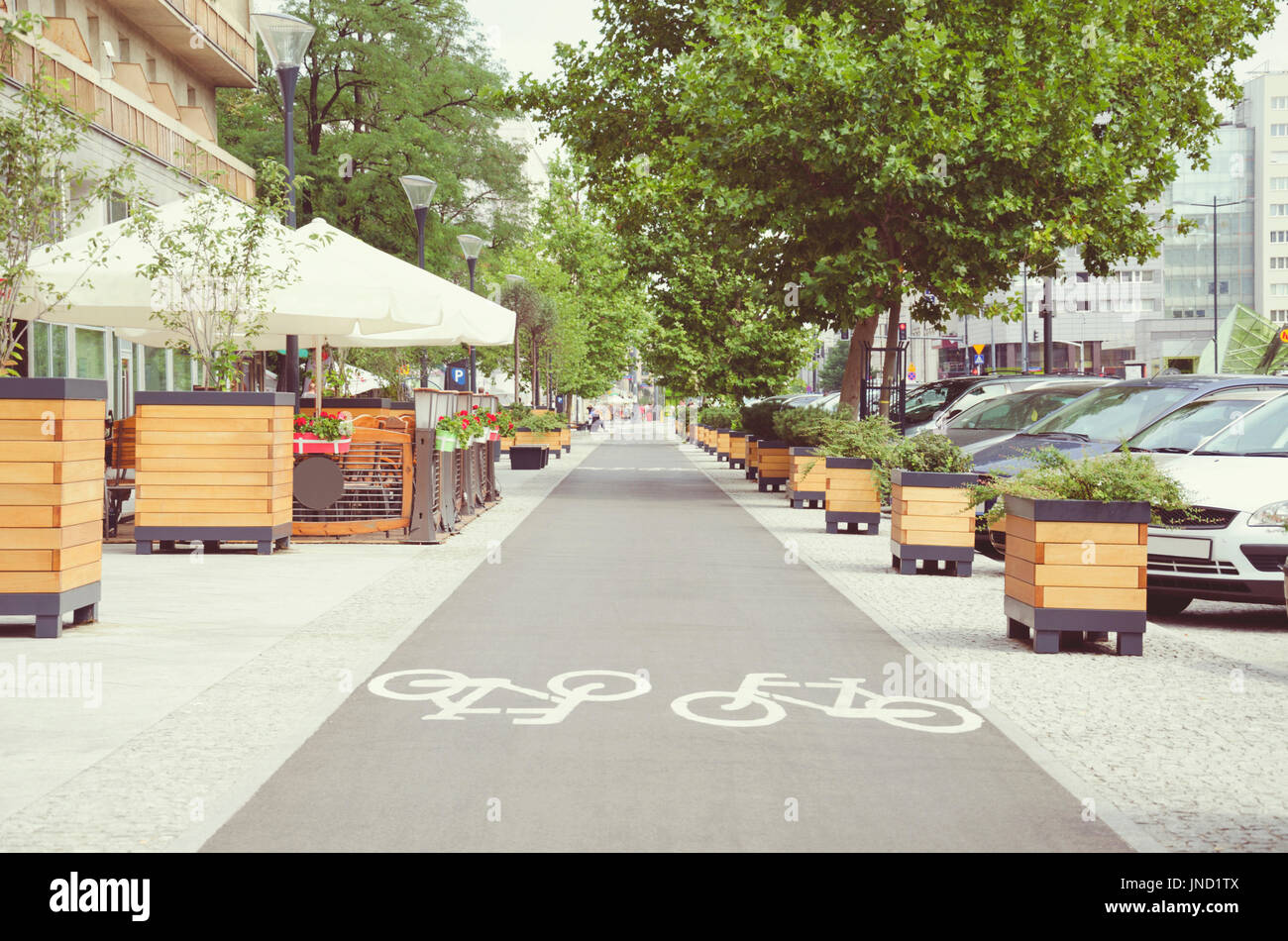 City street with long bicycle lane near outdoor cafe; Vintage effect Stock Photo