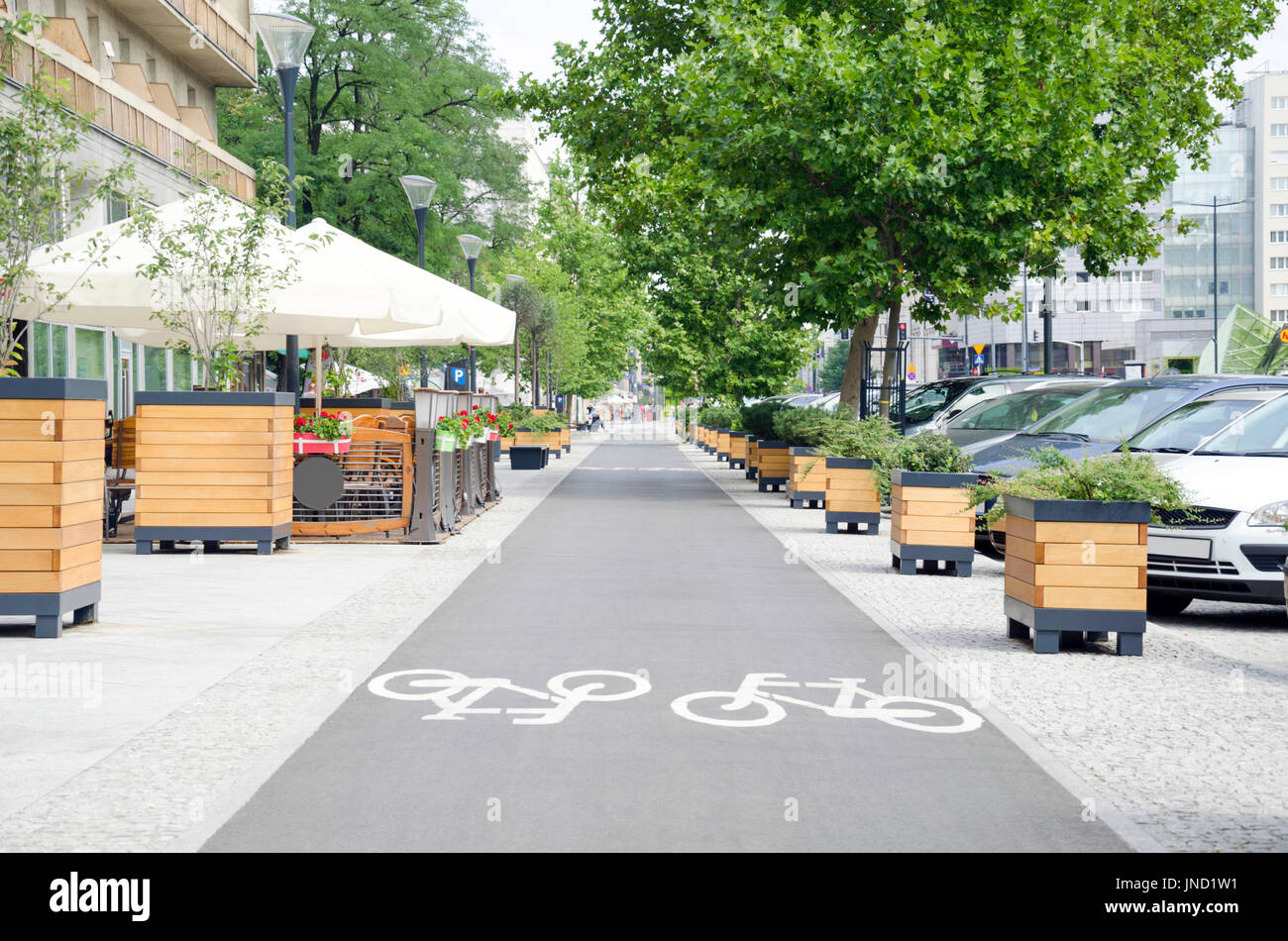 City street with long bicycle lane near outdoor cafe Stock Photo