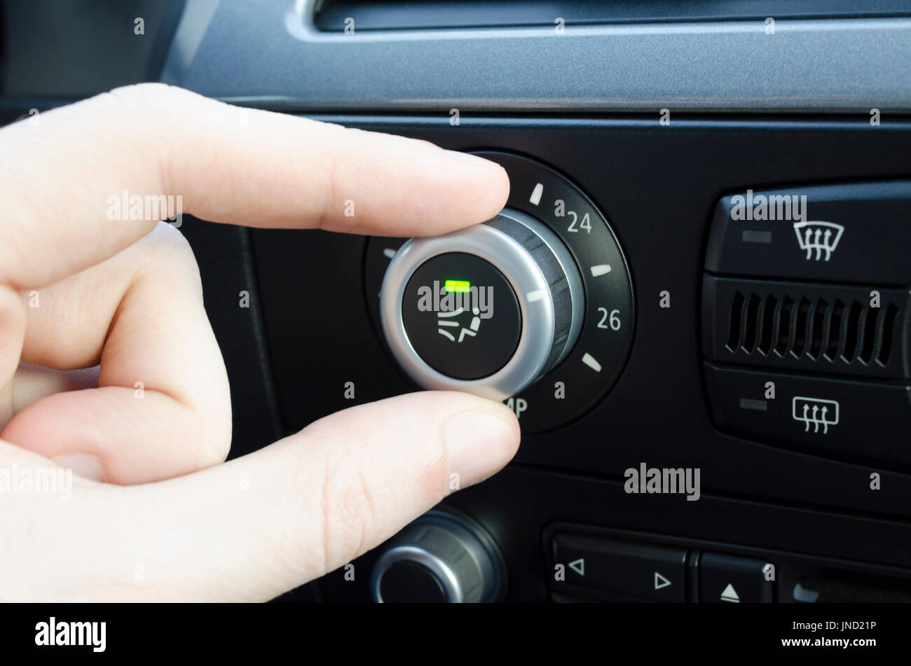 Mens hand setting up the temperature on car climate control system