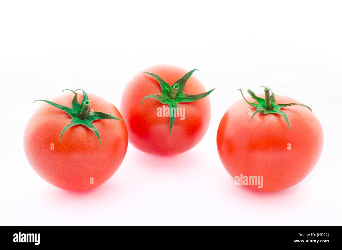 Three fresh raspberry tomatoes isolated on white background Stock Photo
