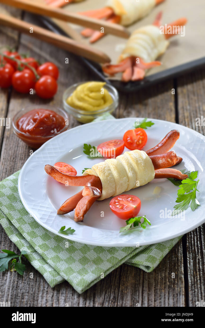 Baked Vienna sausages wrapped with puff pastry fresh from the oven, often served as a children’s meal Stock Photo