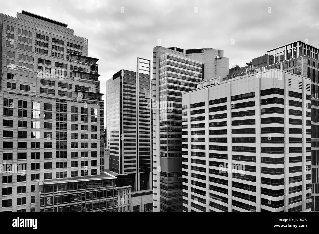 Concrete jungles of modern architecture in Sydney city CBD between tall skyscraper buildings. Geometrical structure of windows, walls, levels and corn Stock Photo