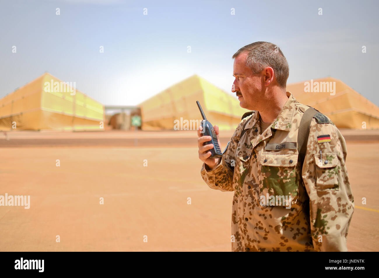 Gao, Mali. 30th July, 2017. Thomas Blum, (Kommandeur gemischter Heeresflieger), speaking into his walkie talkie in front of the hanger for Tiger attack helicopters on the airfield at Camp Castor in Gao, Mali, 30 July 2017. Photo: Britta Pedersen/dpa/Alamy Live News Stock Photo