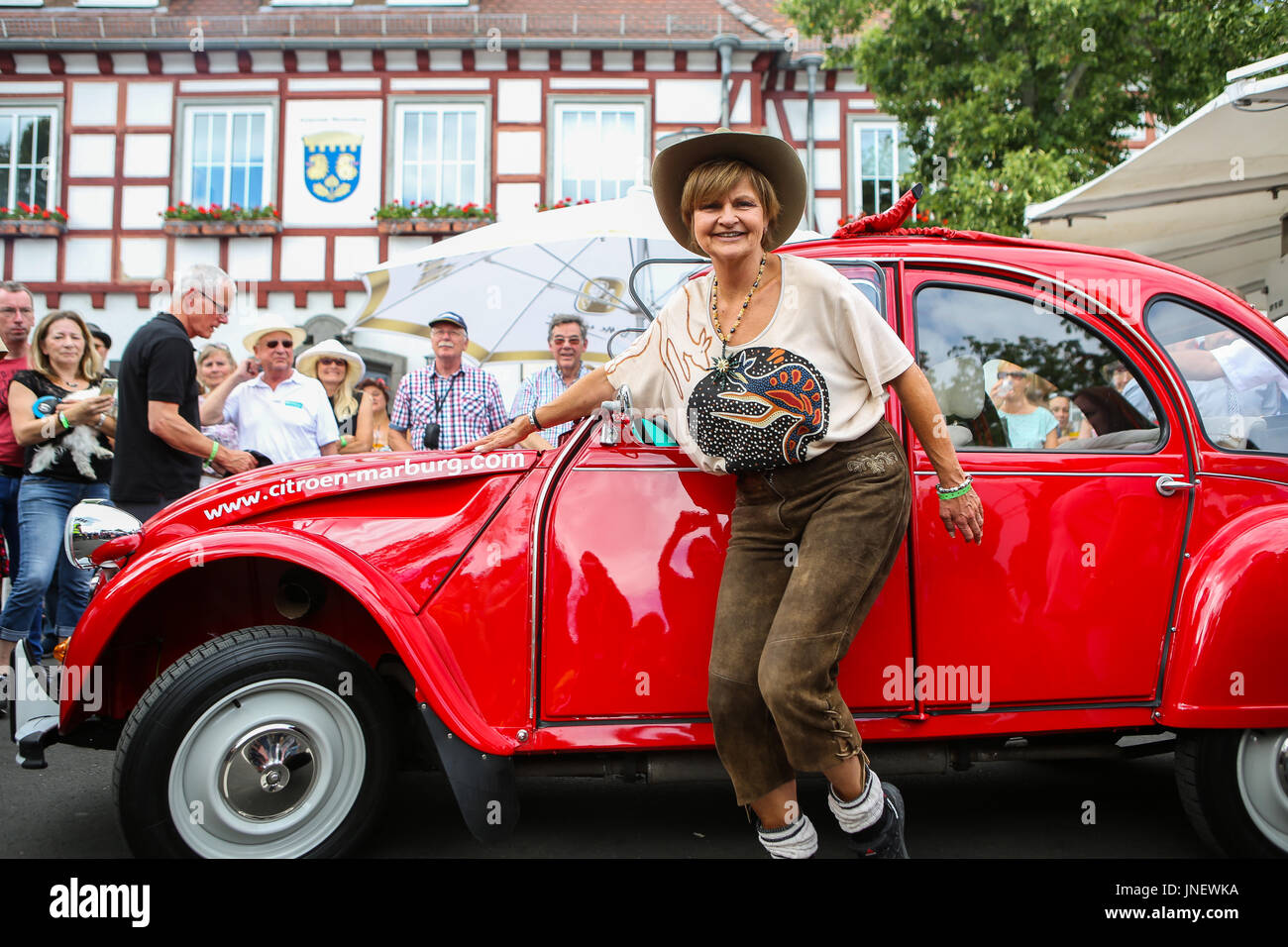 Wettenberg, Germany. 29th July, 2017. Frl. Menke meets a model of her first own car - a Citroën 2CV - at Golden Oldies Festival in Wettenberg, Germany. Frl. Menke (born November 4, 1960 as Franziska Menke in Hamburg, Germany) was a star of the Neue Deutsche Welle genre of German popular music in the early 1980s. The Golden Oldies Festival is a annual nostalgic festival (est. in 1989) with focus on 1950s to1970s, over 1000 exhibited classic cars and old-timers, over 50 live bands. - Credit: Christian Lademann Stock Photo