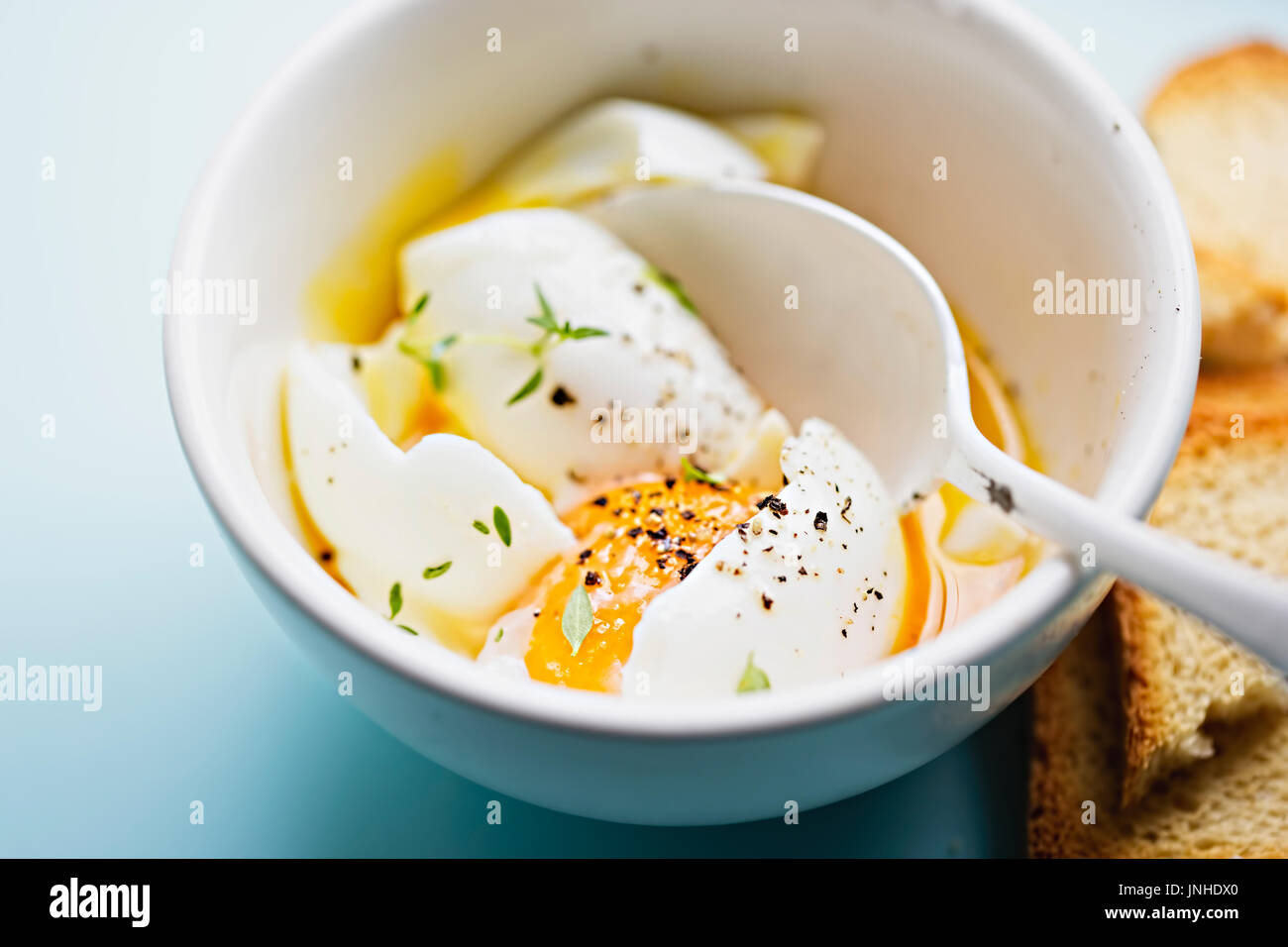 Soft boiled eggs with salt, pepper thyme and rusk bread Stock Photo