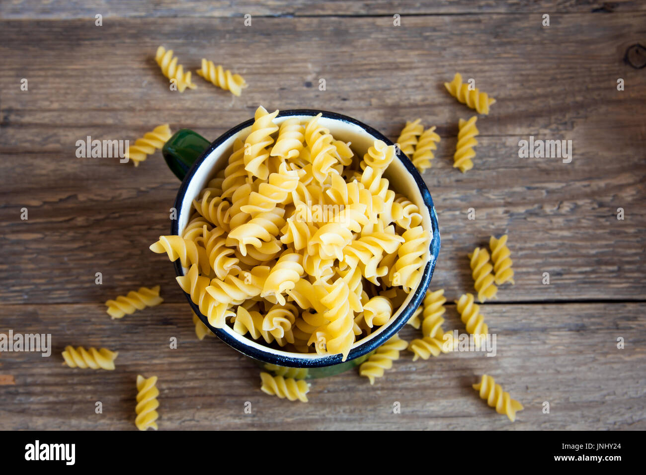 Uncooked raw italian fusilli pasta in rustic metal mug with copy space - healthy ingredient for cooking Stock Photo