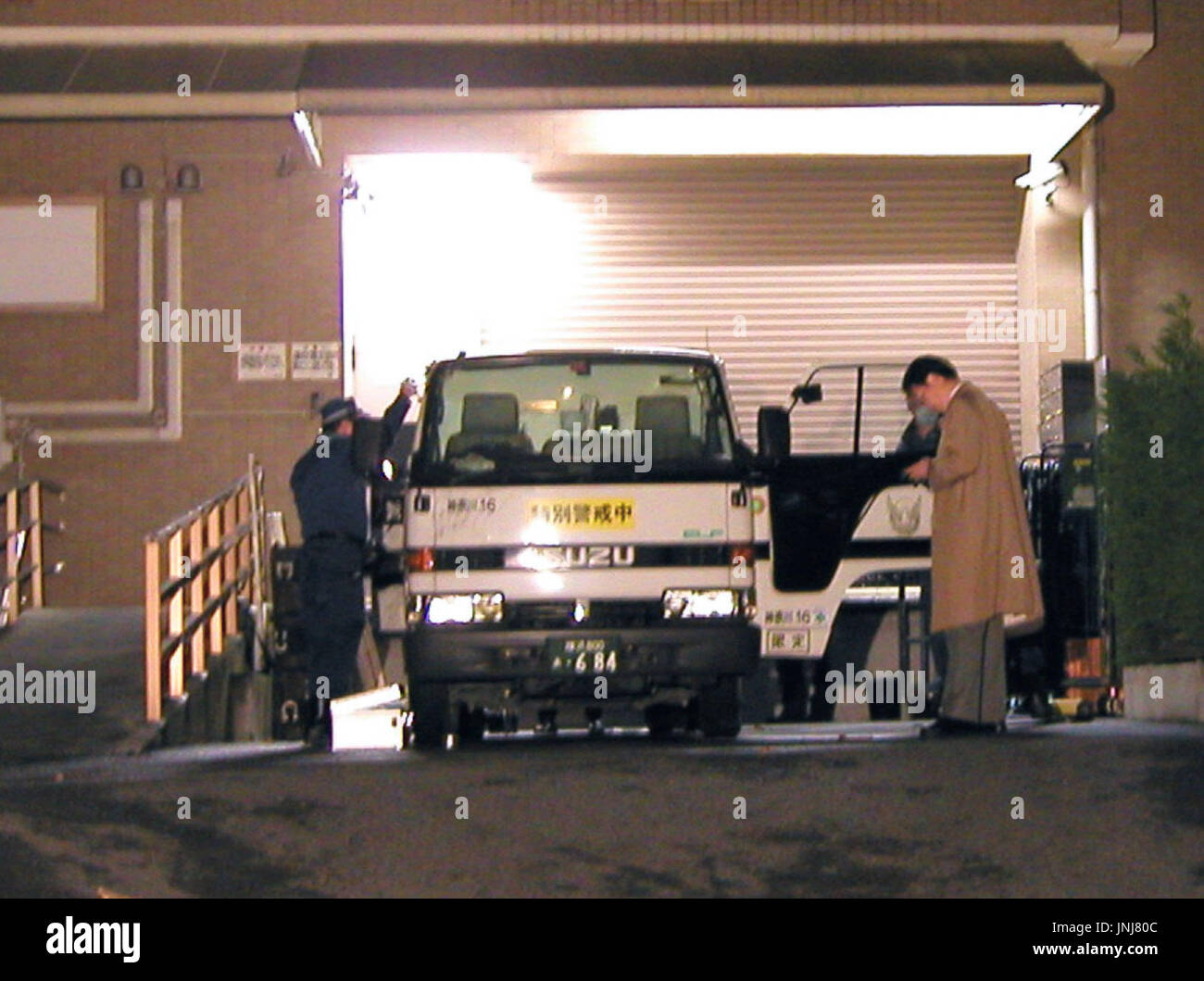 YOKOHAMA, Japan - Police officers check an armored van attacked near a ...