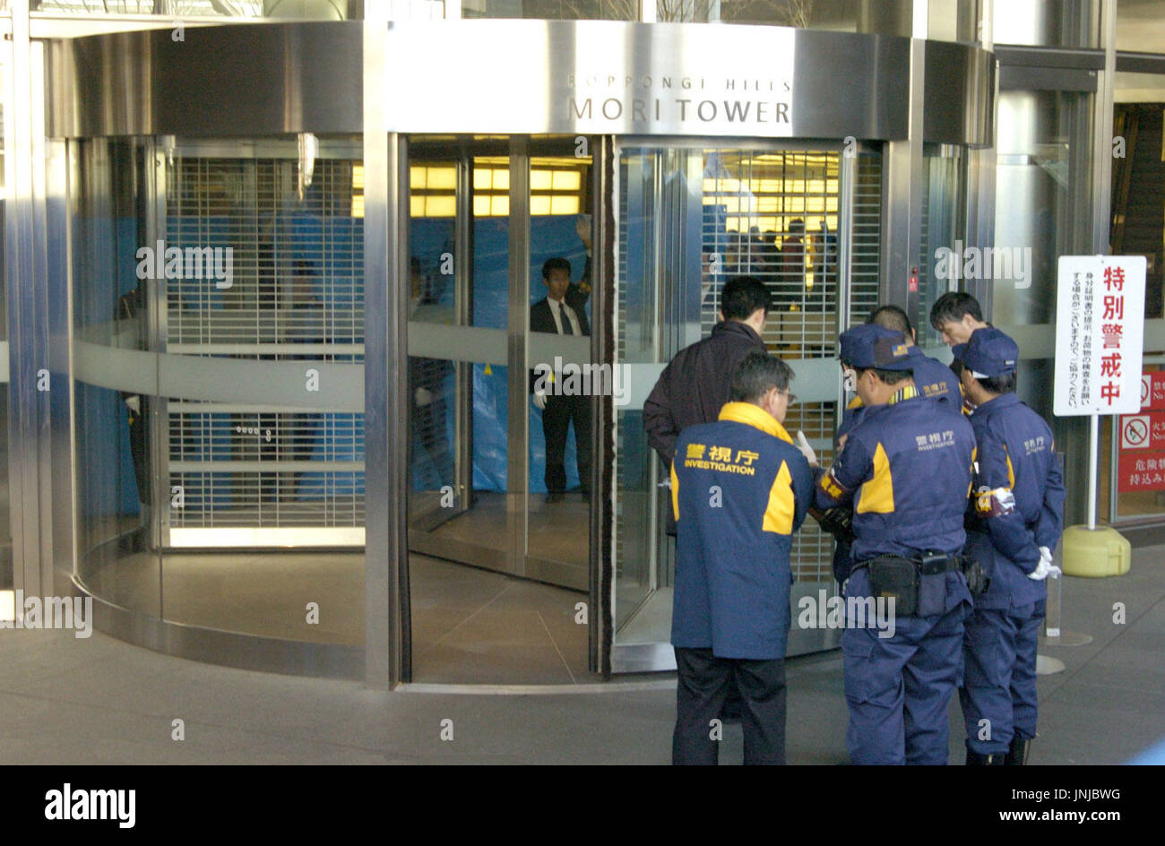 TOKYO, Japan - Police officers examine a revolving door at the