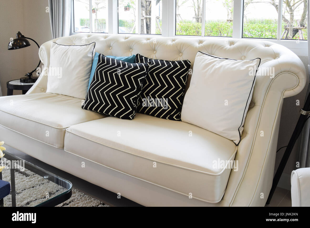 White And Blue Pillows On A White Leather Couch In Vintage Living