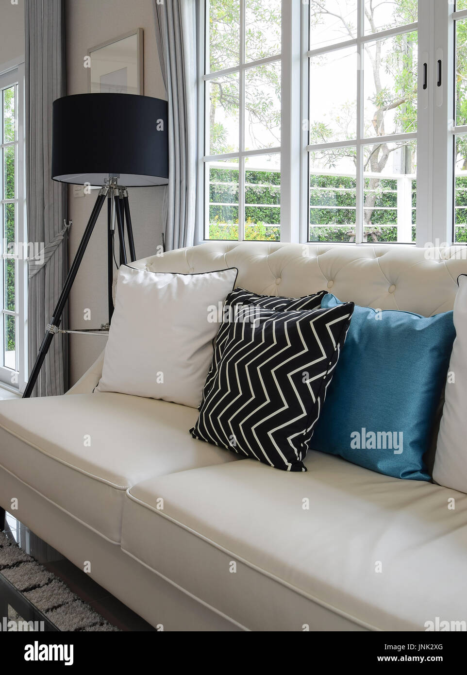 White And Blue Pillows On A White Leather Couch In Vintage Living