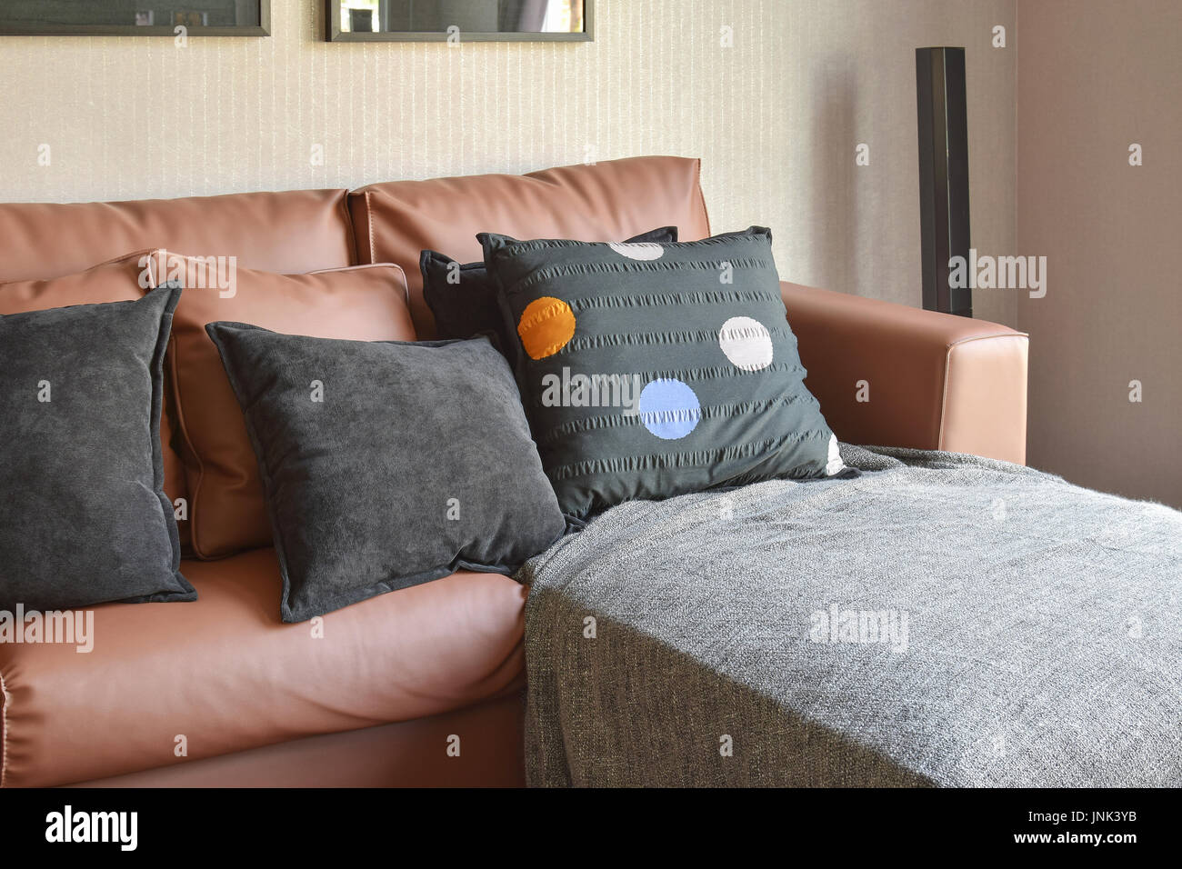 modern living room design with brown leather sofa and black pillows