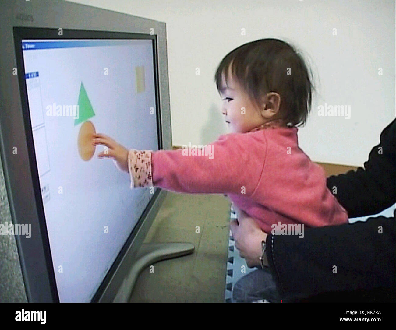 TOKYO, Japan - A boy traces a moving graphic symbol on a computer ...
