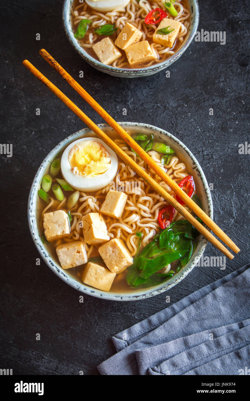 Japanese ramen soup with tofu and egg on dark stone background. Miso