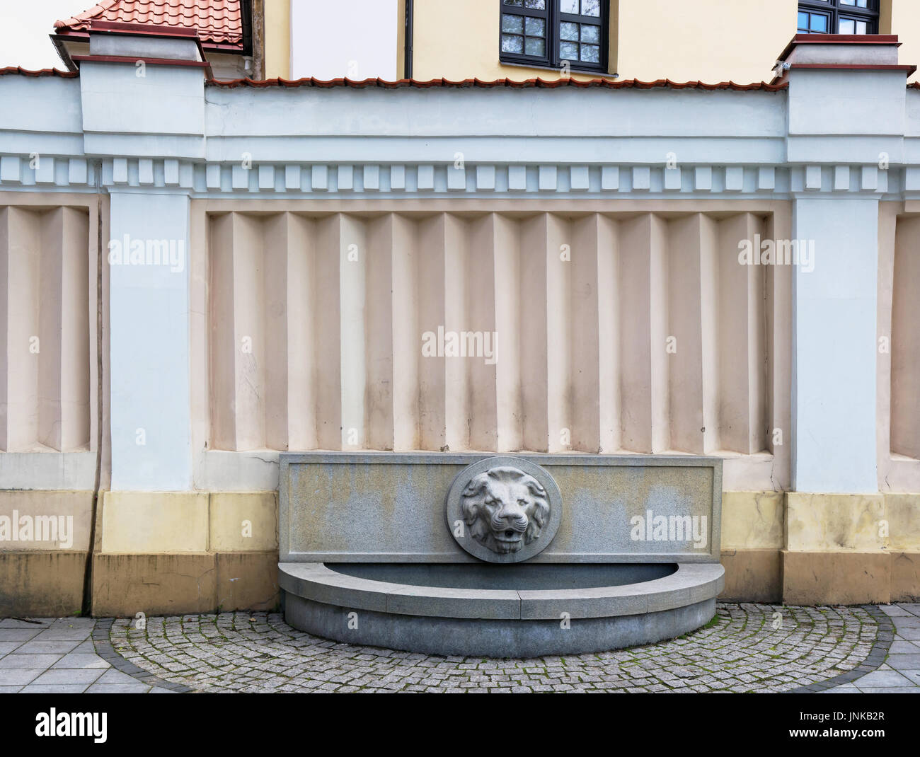 Ordinary standard fragment of urban design with a small no name public  fountain. Construction basis is made of granite stones. The gypsum head of  the Stock Photo - Alamy