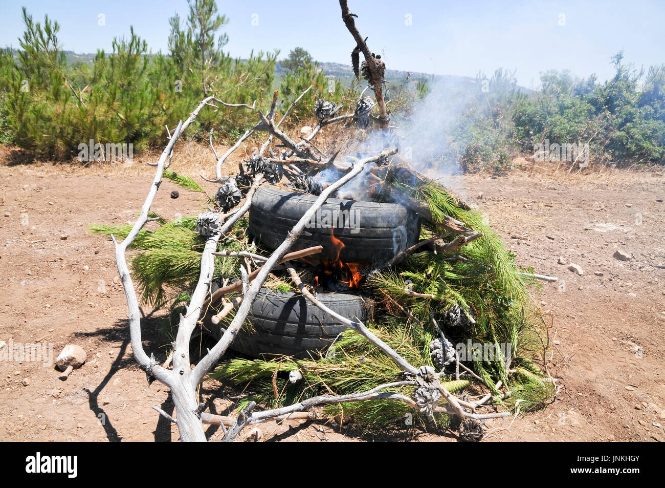 How to start a fire with old tires and branches. a set of 5 images Stock Photo