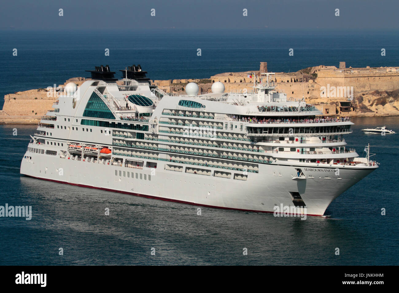Mediterranean travel. The modern cruise ship or liner Seabourn Encore entering Malta's Grand Harbour, with Fort Ricasoli visible in the background Stock Photo