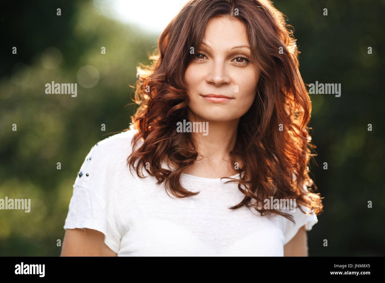 Portrait of young attractive woman at summer green park Stock Photo