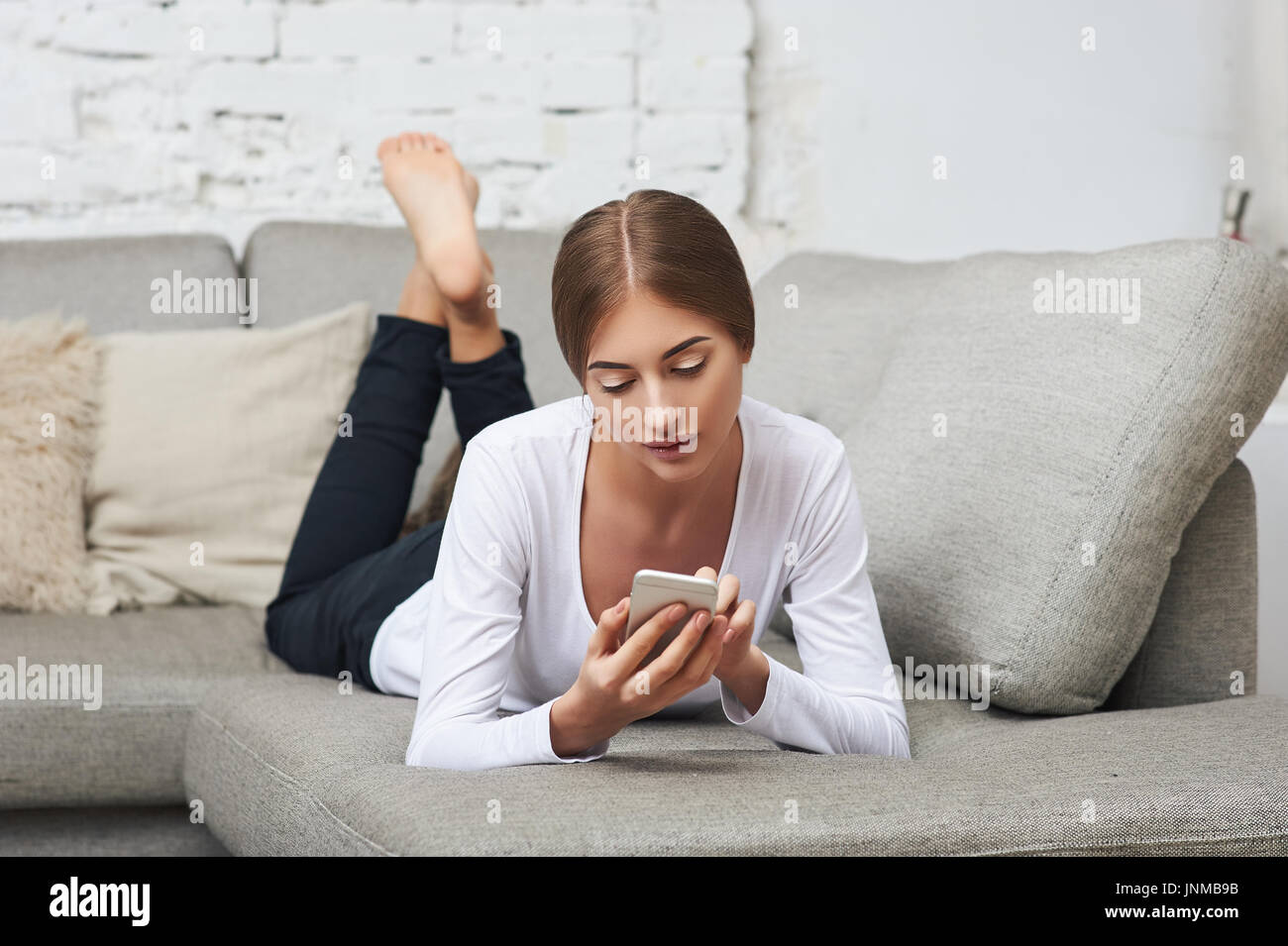Barefoot girl lying on couch hi-res stock photography and images - Alamy