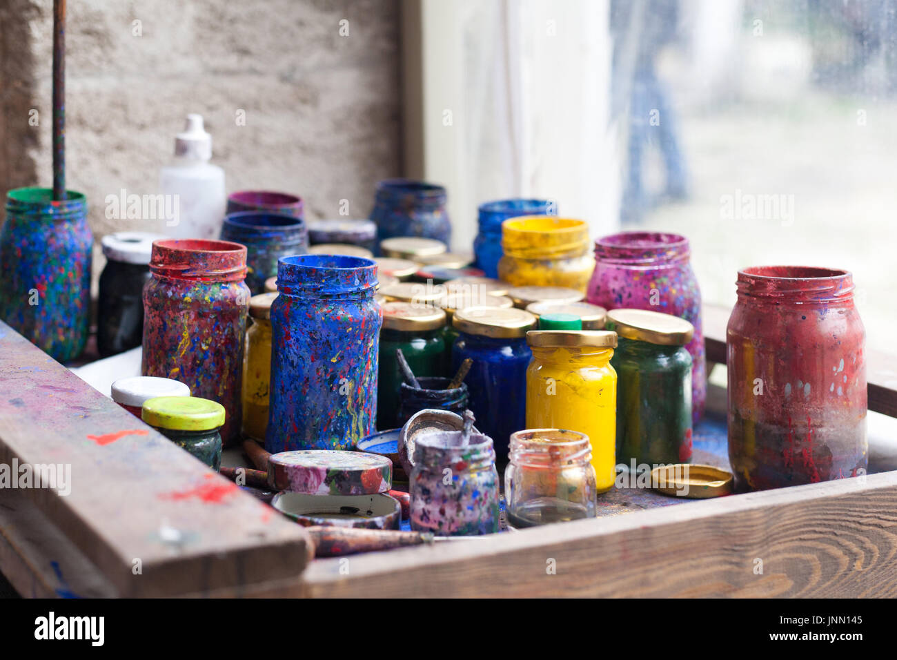 Color jars and tempera on working table in ceramic lab in turkey Stock