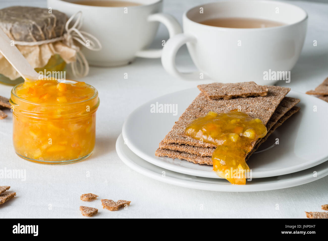 Brown rye crisp bread (Swedish crackers) with spread orange jam and