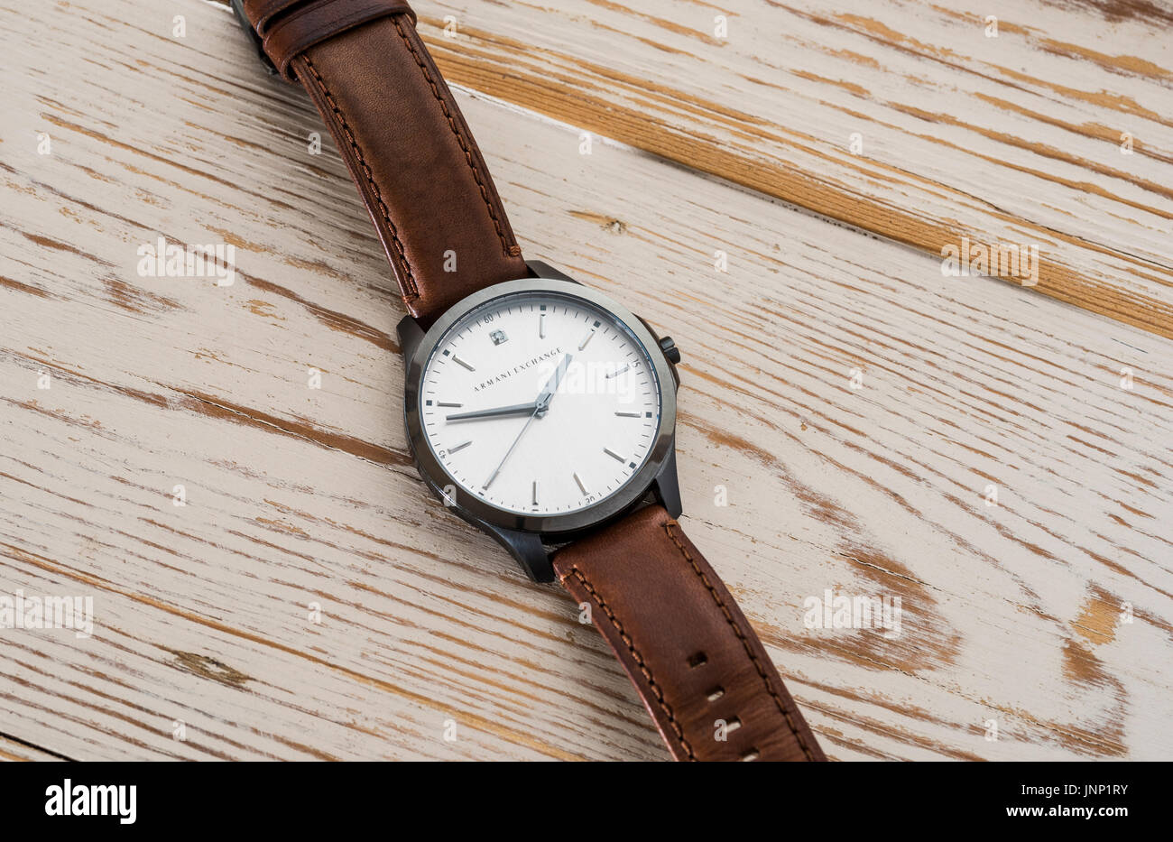 Armani Exchange wristwatch with brown leather strap. Stock Photo
