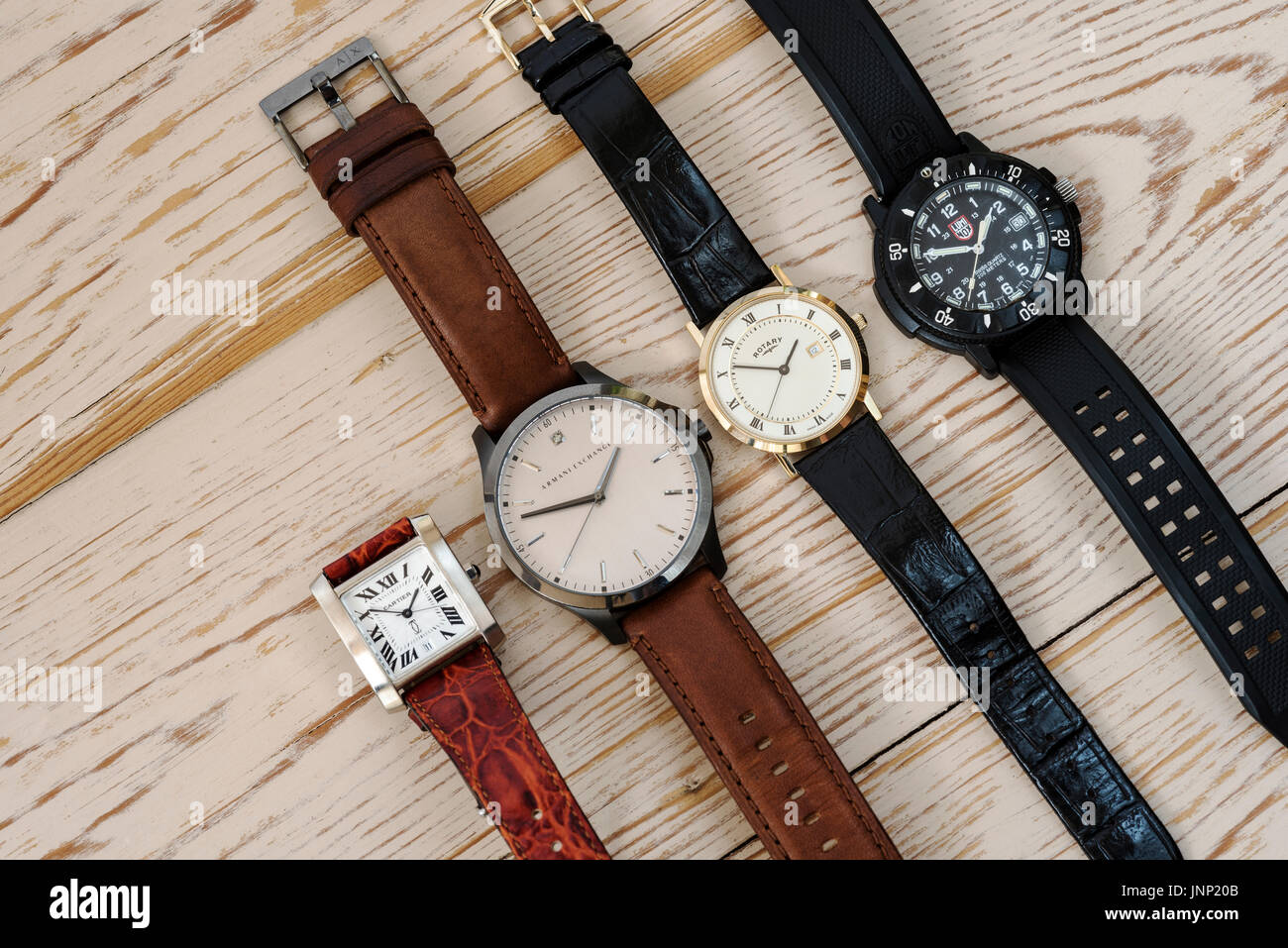 Group of four mens wristwatches, on a wooden background. Stock Photo