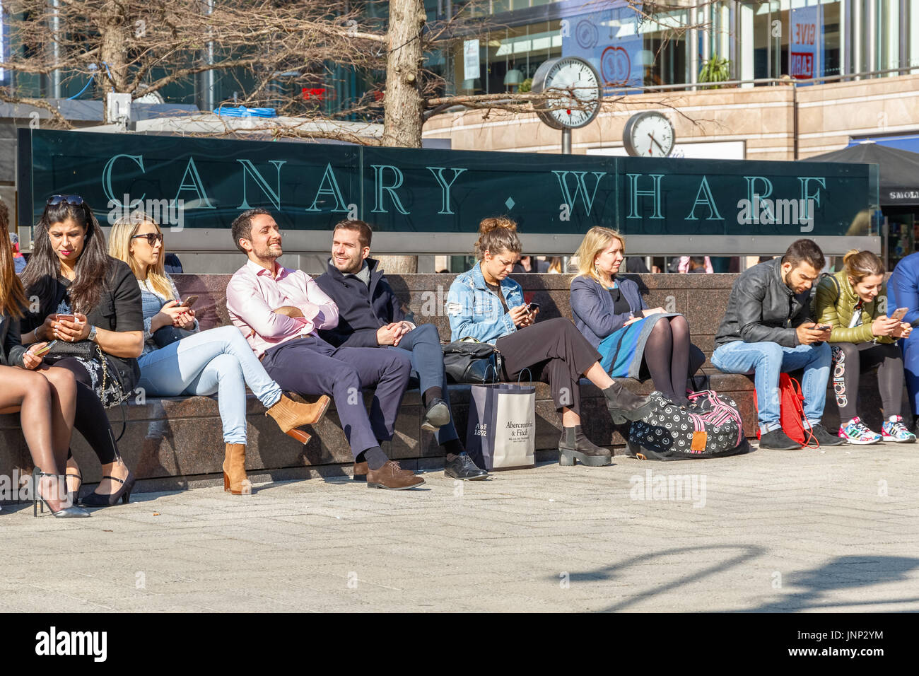 London, UK - May 10, 2017 - Outdoor space in Canary Wharf packed with people sitting and enjoying the sunny day Stock Photo
