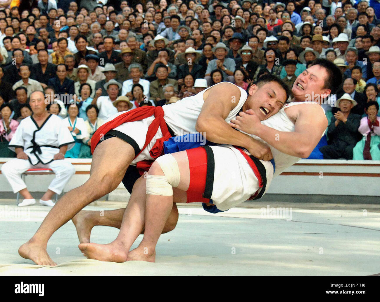 PYONGYANG, North Korea - Ri Jo Won (L) from North Phyongan Province in North Korea battles in a national ''ssirum,'' or Korean wrestling, tournament in Pyongyang on Sept. 25, 2009. Ri, 30, came first at the catch-weight event in which 20 grapplers competed. (Kyodo) Stock Photo