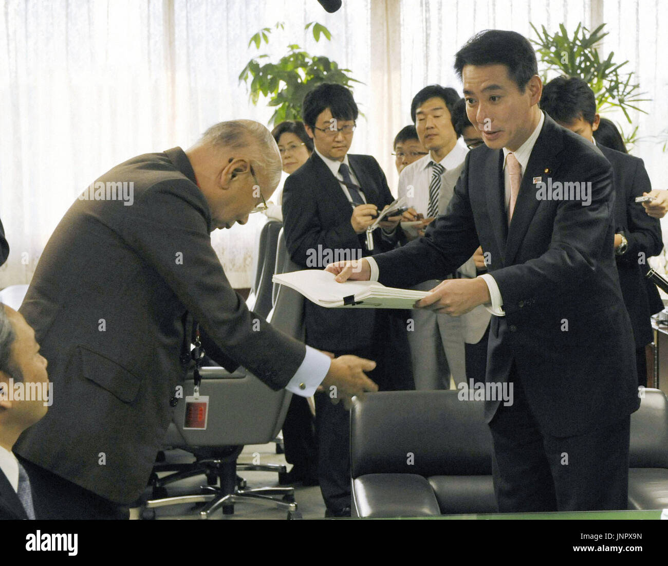 TOKYO, Japan Transport minister Seiji Maehara (R) receives a report