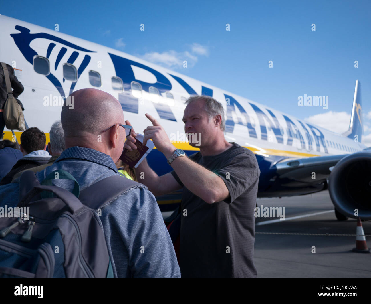 Passengers boarding Ryanair aircraft with boarding pass and passport