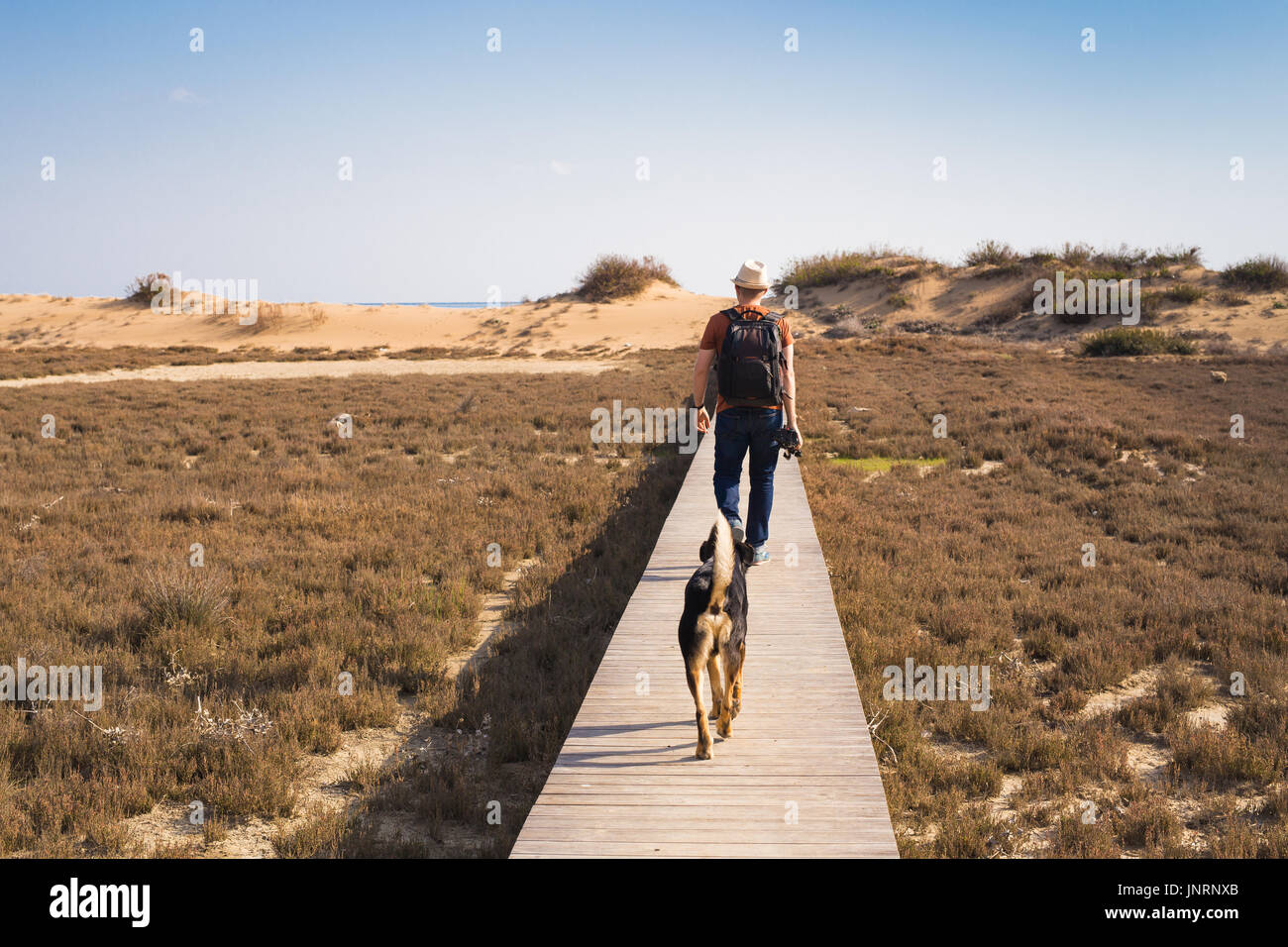 Outdoors lifestyle image of travelling man with cute dog. Tourism concept. Stock Photo