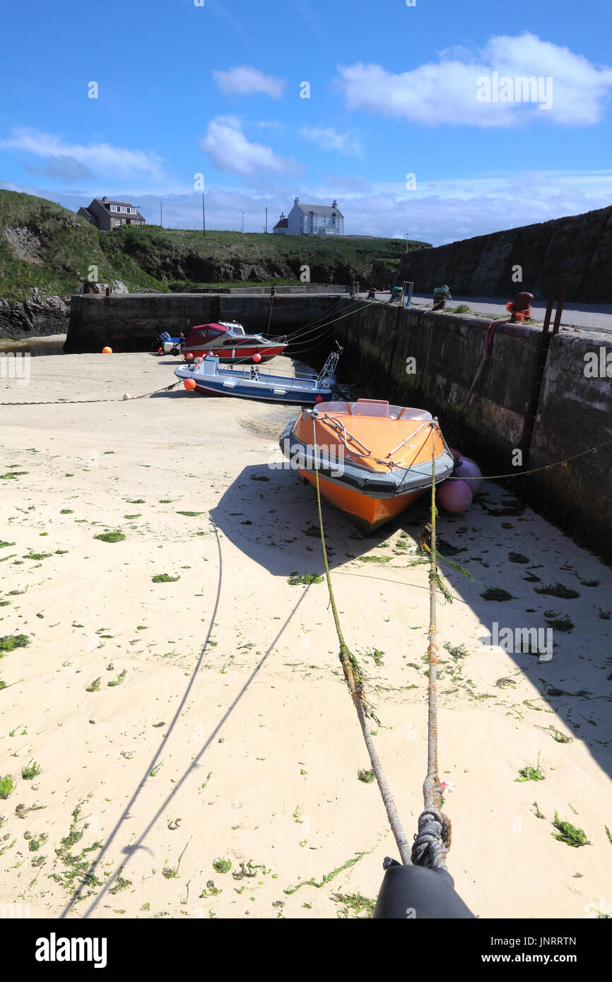 Boats at low tide in Port of Ness harbour, Harris and Lewis, Scotland Stock Photo