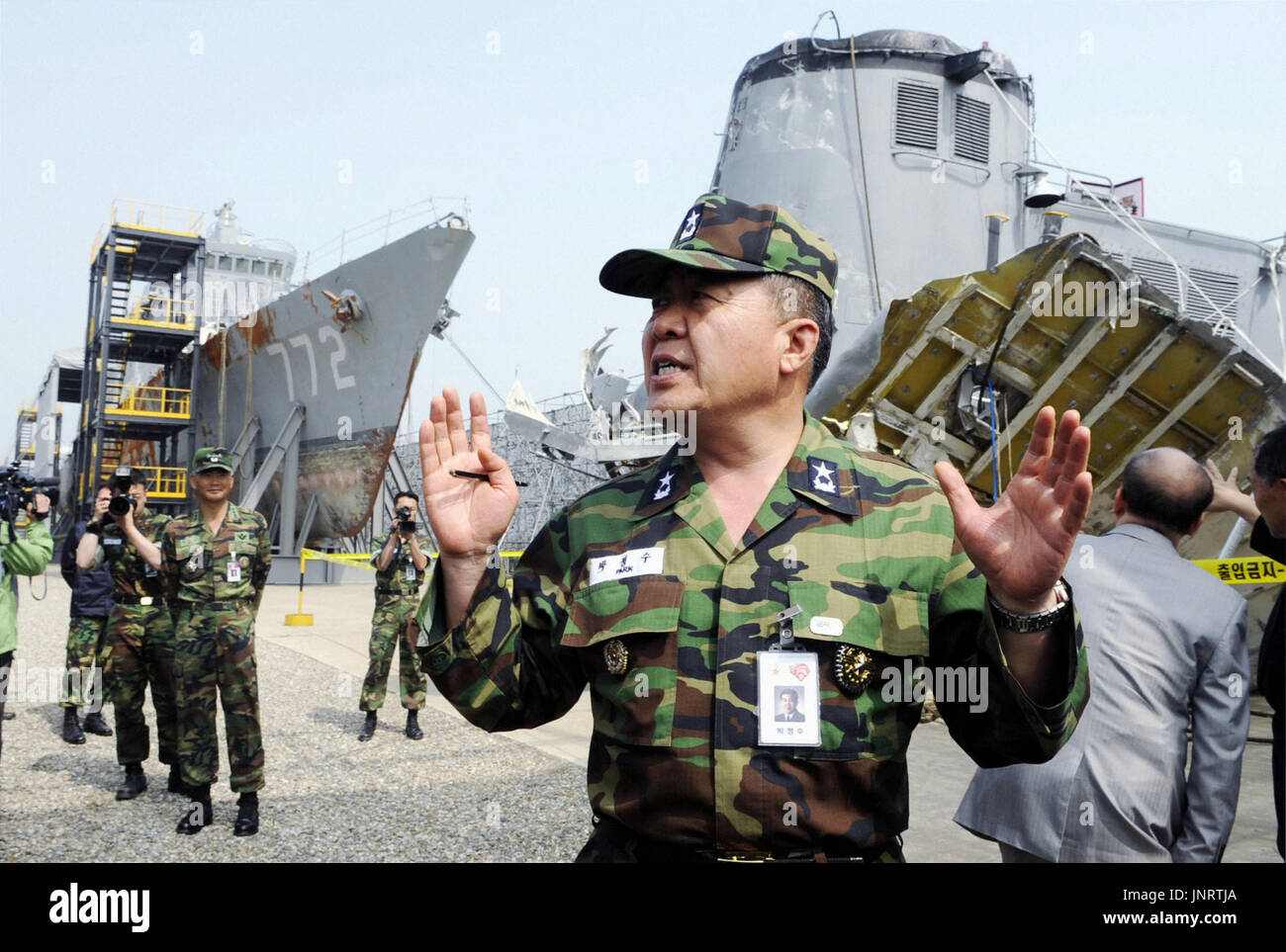 SEOUL, South Korea - A member of a joint investigation team of the South Korean military and the private sector talks about the deadly sinking of the country's naval ship Cheonan near the salvaged ship at a naval base in Gyeonggi Province on May 19, 2010. South Korea officially blamed North Korea the following day for the sinking of the warship that killed 46 sailors. (Kyodo) Stock Photo