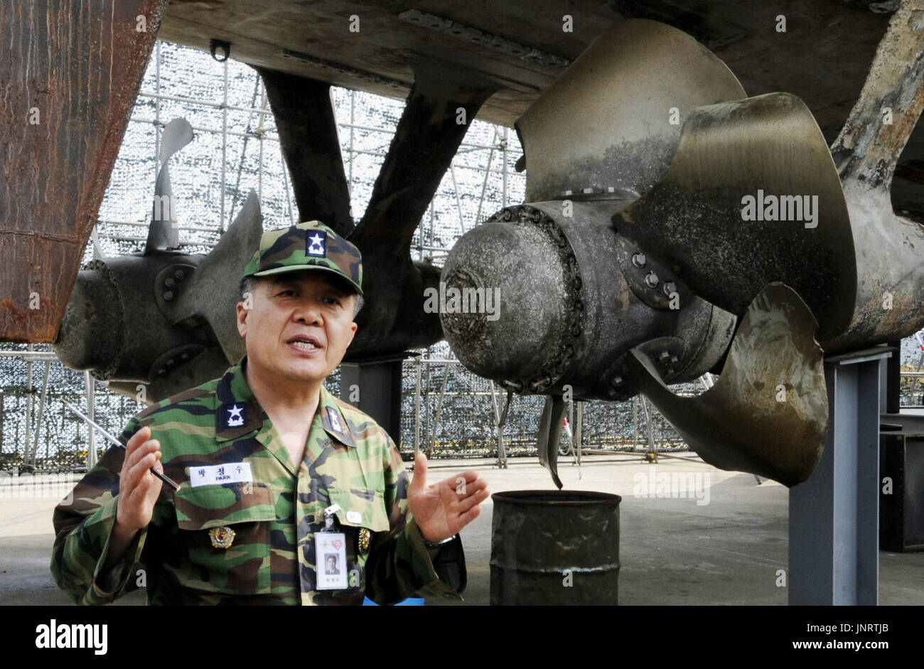 SEOUL, South Korea - A member of a joint investigation team of the South Korean military and the private sector talks about the deadly sinking of the country's naval ship Cheonan near the salvaged ship at a naval base in Gyeonggi Province on May 19, 2010. South Korea officially blamed North Korea the following day for the sinking of the warship that killed 46 sailors. (Kyodo) Stock Photo